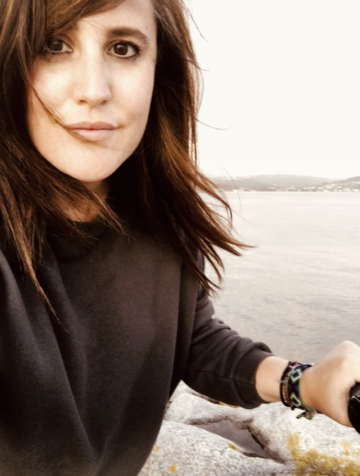 Ivana á beira do mar, co cabelo movido polo vento